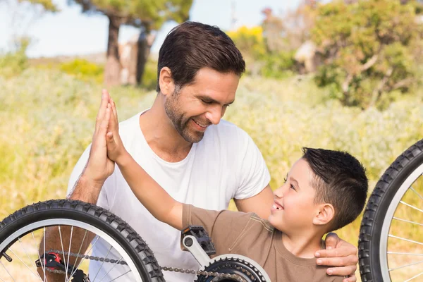 Padre e figlio riparano la bici insieme — Foto Stock