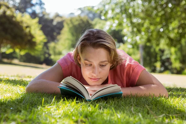 きれいな女性が公園で本を読んで — ストック写真