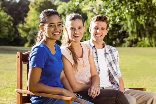 Happy friends sitting on bench — Stock Photo, Image