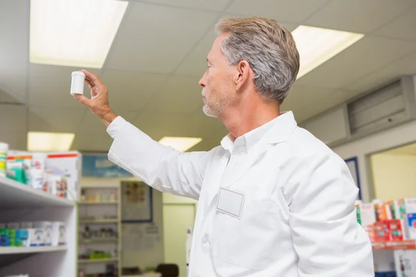 Senior pharmacist looking at medicine — Stock Photo, Image