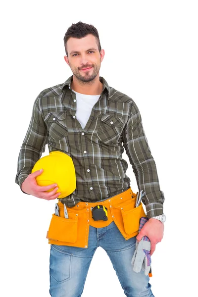Handwerker trägt Werkzeuggurt und hält Helm und Handschuhe in der Hand — Stockfoto