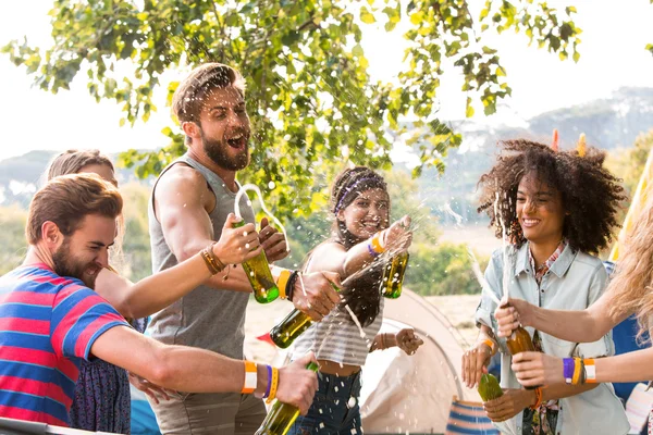 Hipsters rociando cerveza uno sobre el otro Imagen de stock