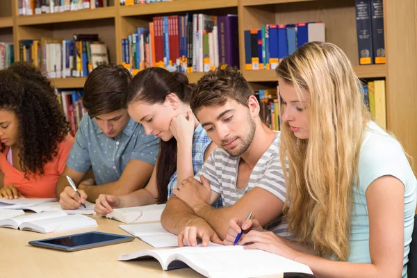 Studenti universitari che fanno i compiti in biblioteca — Foto Stock