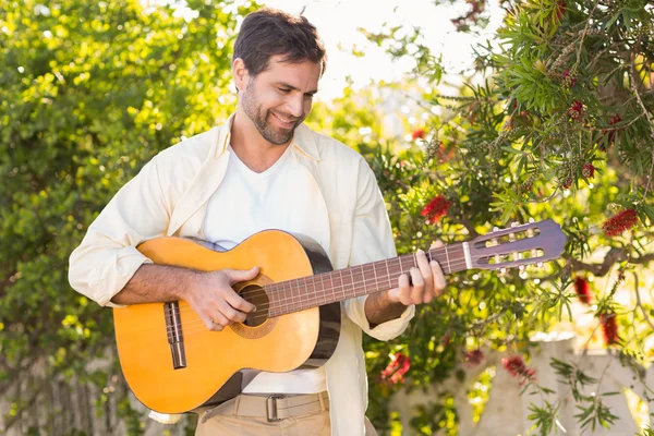 Man smiling at camera playing guitar Stock Image