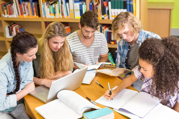 Étudiants faisant leurs devoirs à la bibliothèque Image En Vente