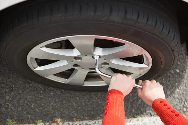 Woman replacing tire Stock Photo