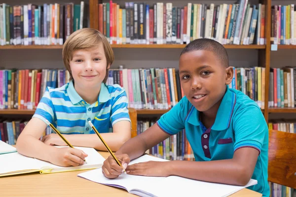 Cute pupils drawing in library Stock Picture