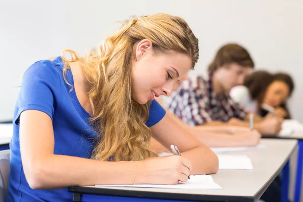 Students writing notes in classroom Royalty Free Stock Photos