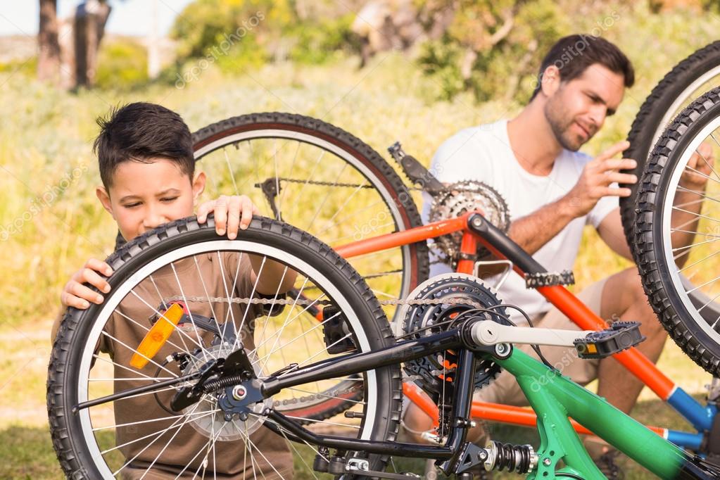 Father and son repairing bike together Stock Photo by