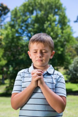 Little boy saying his prayers clipart