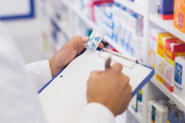 Pharmacist writing on clipboard clipart