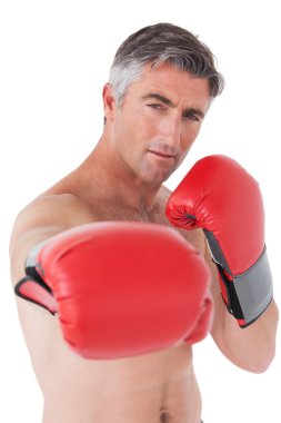 Fit man punching with boxing gloves clipart