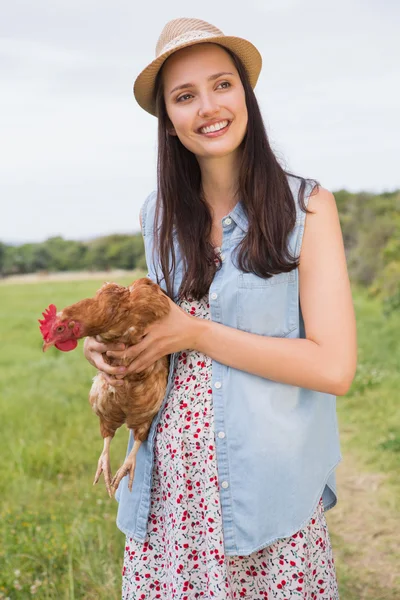 Happy brunette holding her chicken — Stock Photo, Image