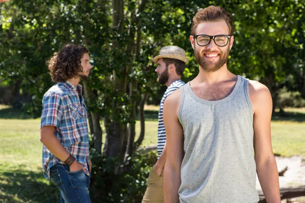 Hipster glimlachen op camera in het park — Stockfoto