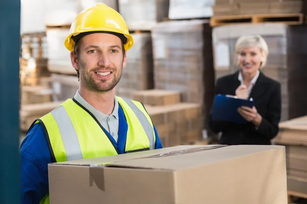 Warehouse worker holding box — Stock Photo, Image