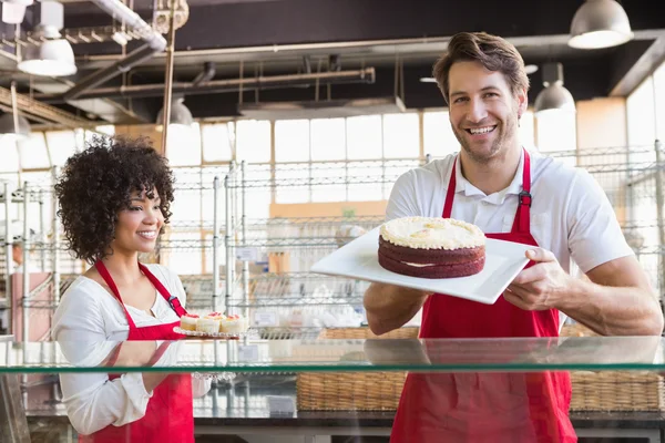 Colleagues in uniform showing cakes — Stock Photo, Image