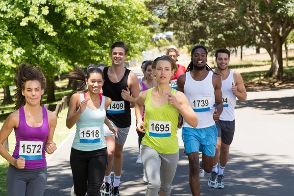 Glückliche Menschen laufen Rennen im Park — Stockfoto