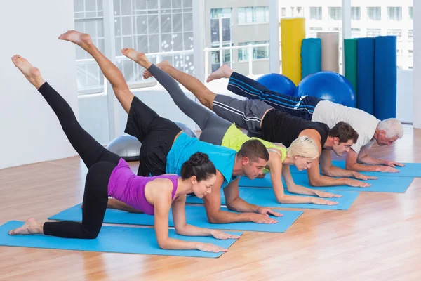 Personas que hacen ejercicio en colchonetas de fitness en el gimnasio —  Fotos de Stock