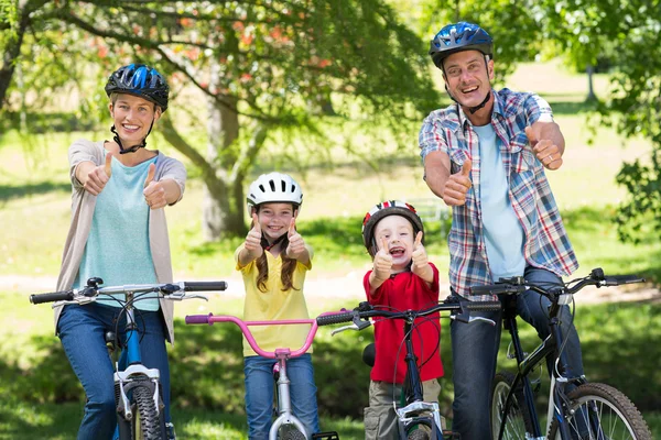 Familie op fiets met duimen omhoog in het park — Stockfoto