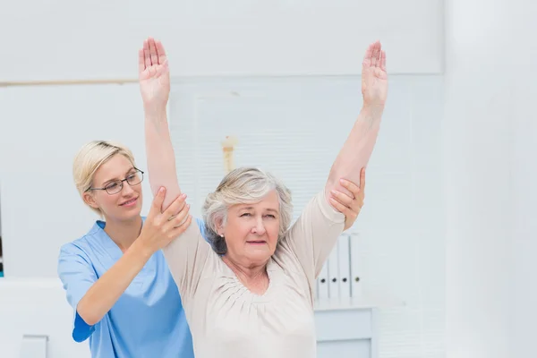 Verpleegkundige helpen vrouwelijke patiënt bij de uitoefening van — Stockfoto