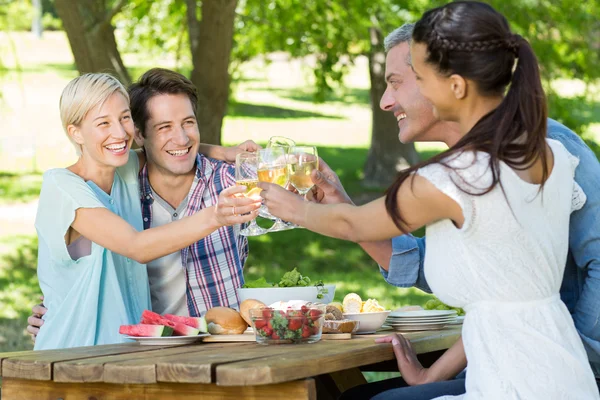 Glückliche Paare stoßen im Park an — Stockfoto