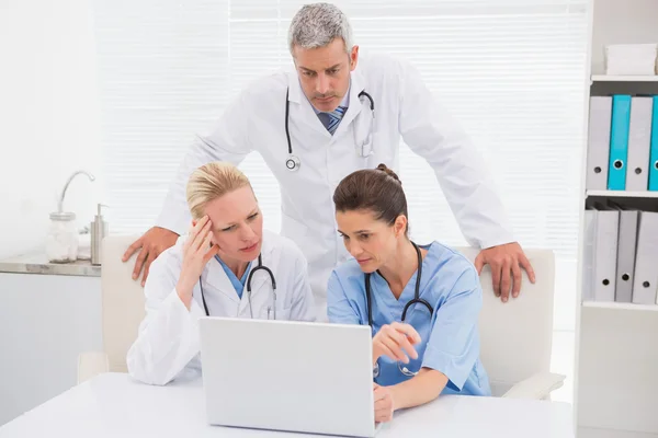 Los médicos mirando a la computadora portátil — Foto de Stock