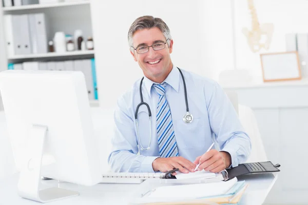 Feliz doctor inteligente escribiendo en papel — Foto de Stock