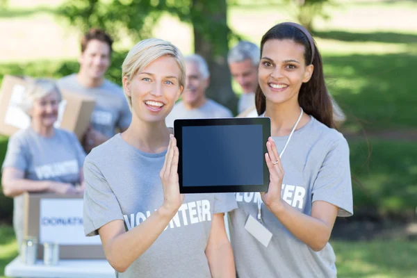 Volontär vänner visar tablet pc-skärmen — Stockfoto