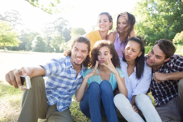 Amigos sonrientes en el parque tomando selfie —  Fotos de Stock