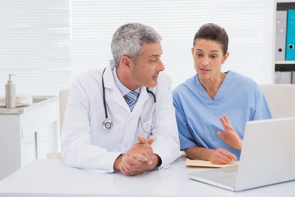 Los médicos mirando a la computadora portátil — Foto de Stock