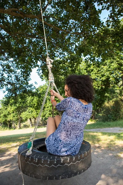Bella giovane donna in pneumatico swing — Foto Stock