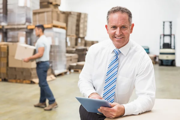 Chefe usando tablet digital no armazém — Fotografia de Stock