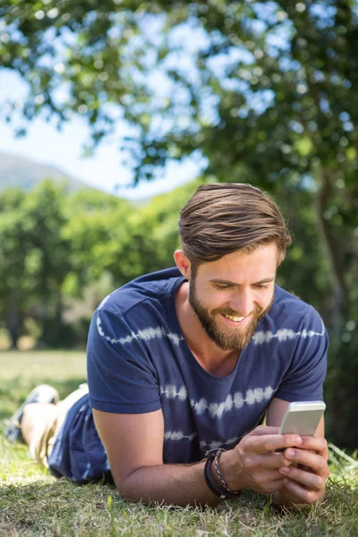 Beau hipster utilisant le téléphone dans le parc — Photo