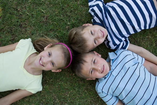 Heureux frères et sœurs souriant à la caméra ensemble — Photo