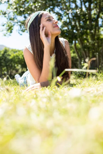 Ładna brunetka leżąca na trawie — Zdjęcie stockowe