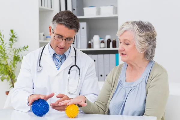 Physiotherapist guiding patient with massage ball — Stock Photo, Image