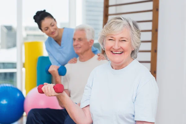 Feliz anciana levantando pesas — Foto de Stock