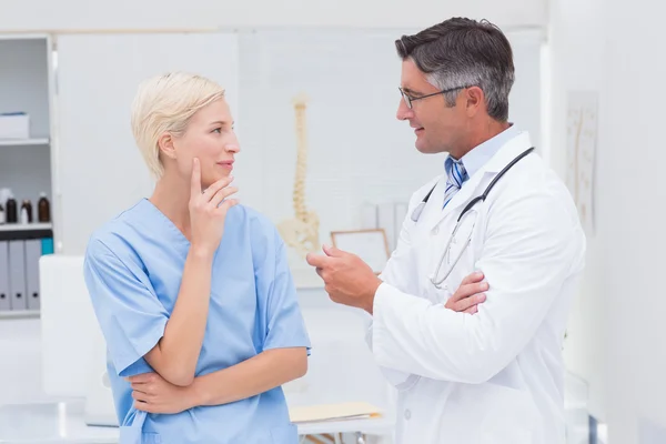 Médico y enfermera discutiendo en clínica — Foto de Stock