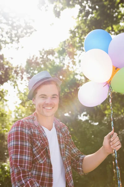 Knappe hipster bedrijf ballonnen — Stockfoto