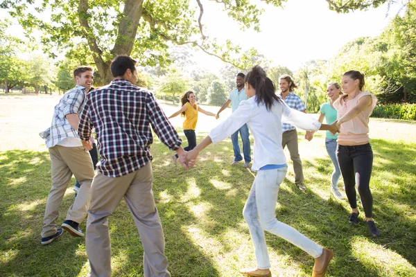 Happy vrienden in het park hand in hand — Stockfoto