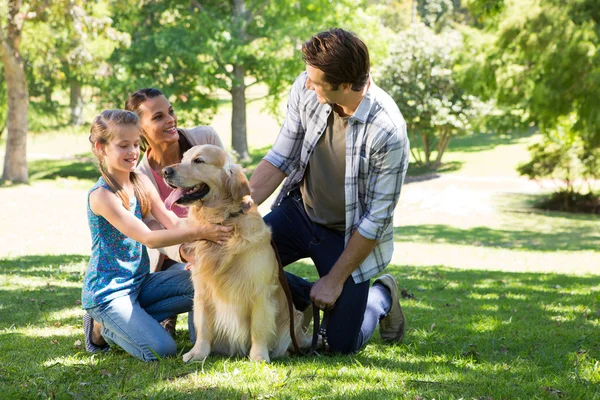Ευτυχισμένη οικογένεια με το σκύλο τους στο πάρκο — Φωτογραφία Αρχείου