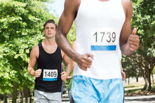 Glückliche Menschen laufen Rennen im Park — Stockfoto