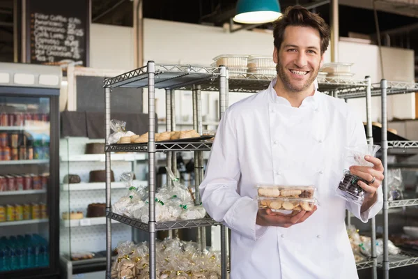 Baker holding coffee house and food — Stock Photo, Image