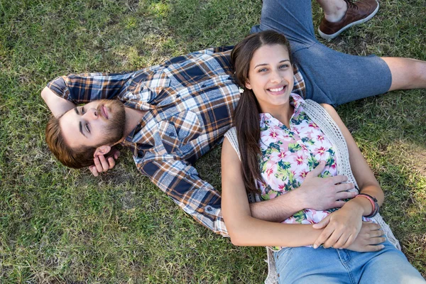 Jovem casal relaxante no parque sorrindo para a câmera — Fotografia de Stock