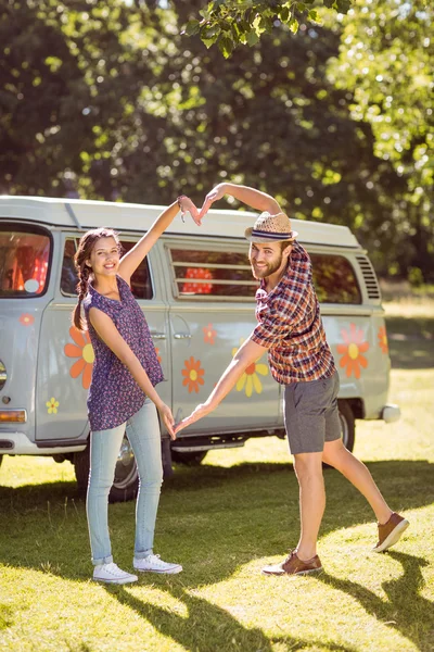 Hipster couple making heart with arms — Stock Photo, Image