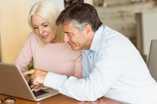 Pareja madura feliz usando el ordenador portátil — Foto de Stock