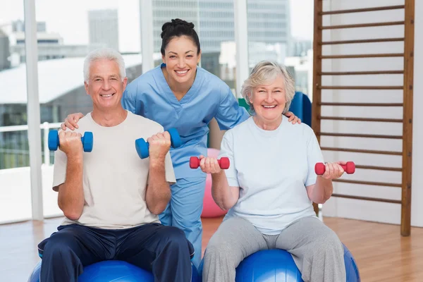 Instructor with arms around senior couple — Stock Photo, Image