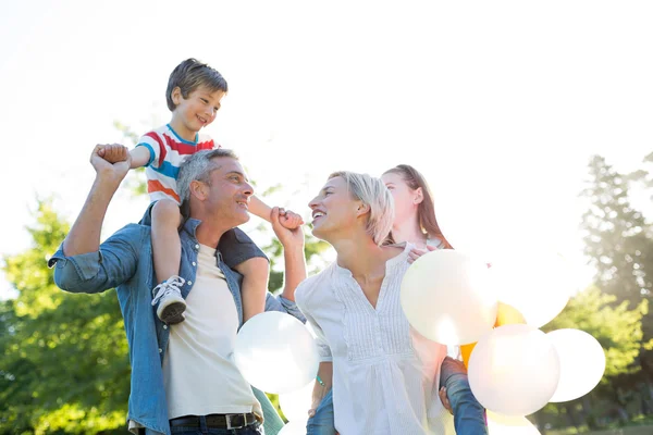 Familia feliz caminando en el parque — Foto de Stock