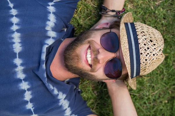 Красавчик-хипстер лежит на траве — стоковое фото