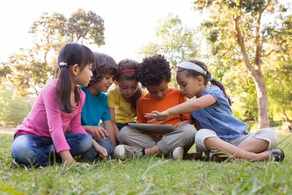 Niños pequeños usando la tableta en el parque —  Fotos de Stock